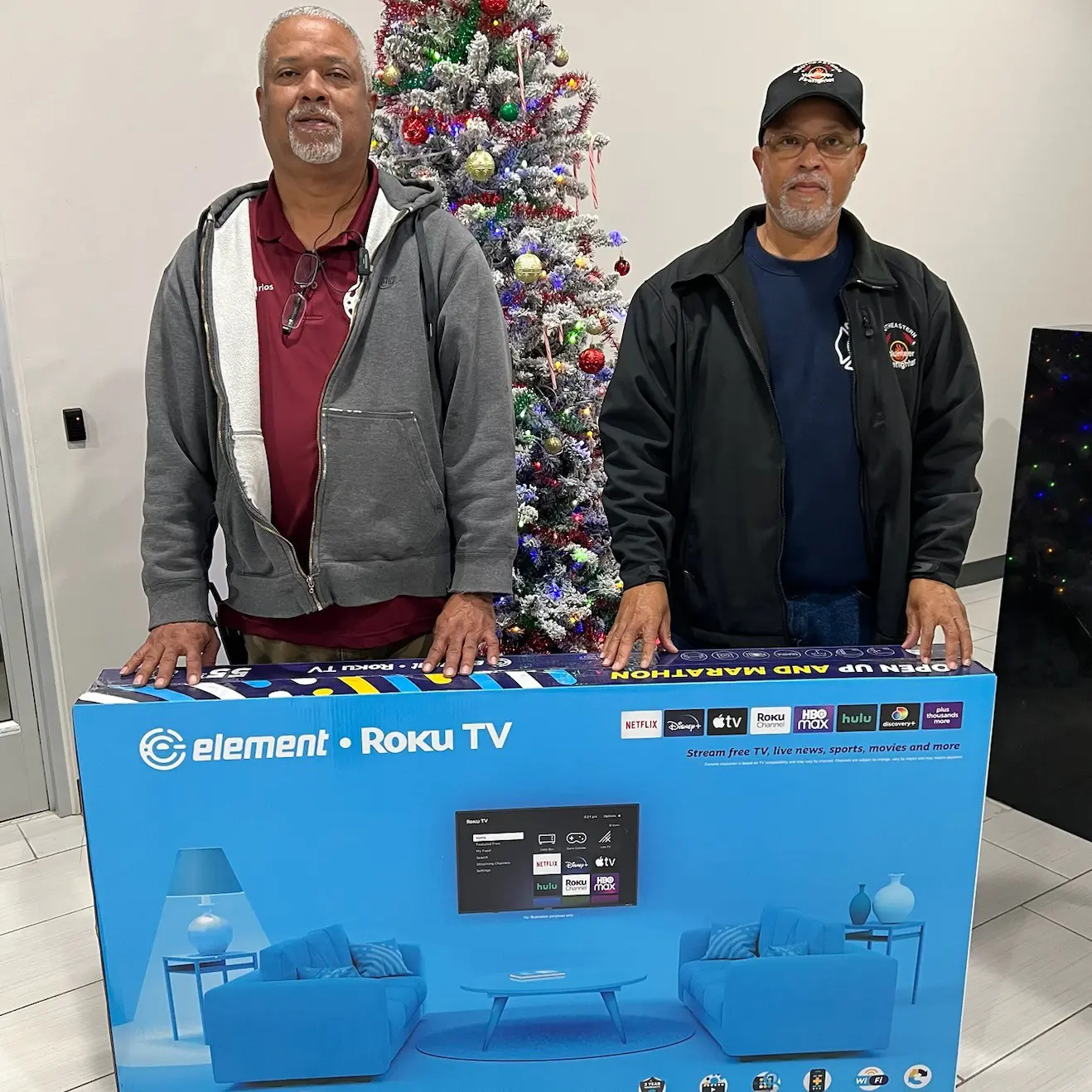 Two men posing with an Element TV box
